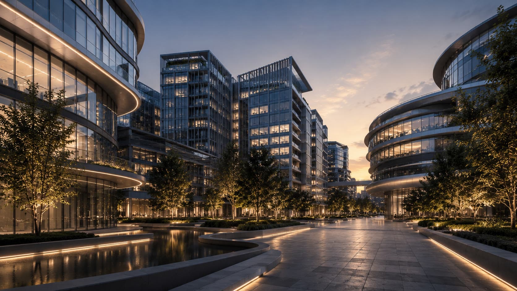 A lit boulevard between curved glass office buildings at dusk, a reflecting pool to one side